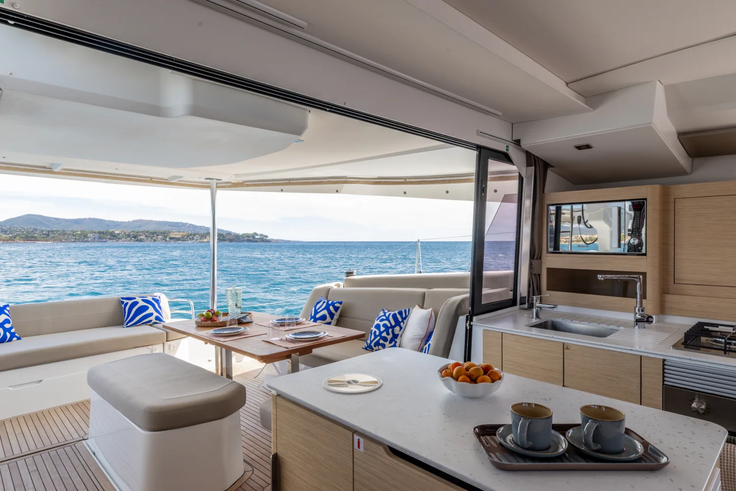Salon mit Pantry und offenem Blick aufs Meer an Bord eines Katamarans